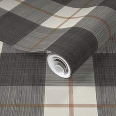 a grey and white plaid wallpaper with a roll of tape on it's side