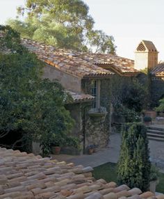 an old stone house surrounded by trees and bushes