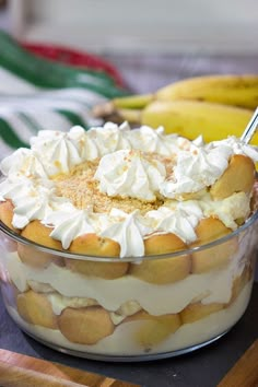 a dessert with whipped cream and bananas in the background