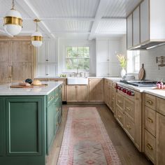 a kitchen with green cabinets and an area rug