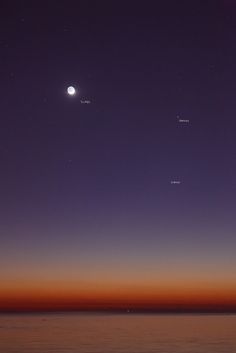 three planets are seen in the sky at night, with an orange and purple hue