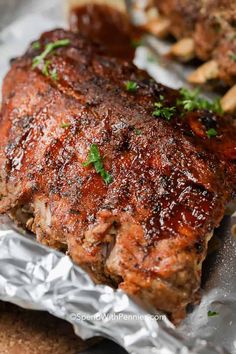 a piece of meat is sitting on tin foil with parsley sprinkled on top