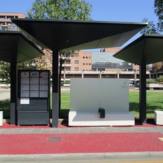 two black and white public restrooms sitting on the side of a road