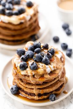 stack of pancakes with blueberries and whipped cream