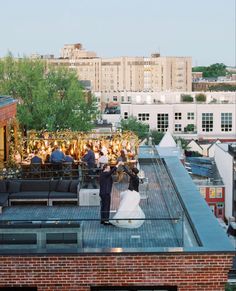 a bride and groom standing on the roof of a building