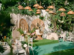 an outdoor event with chairs and tables set up in front of a wall decorated with hanging lights