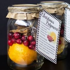 two mason jars filled with oranges and cranberries