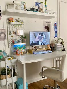 a white desk with a computer on top of it and some shelves above the desk