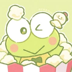 a green frog sitting on top of a pile of popcorn