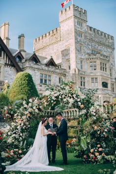 a bride and groom standing in front of a castle