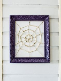 a spider web is hanging on the side of a house in front of a window