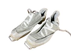 an old pair of white shoes with no laces on them, sitting in front of a white background