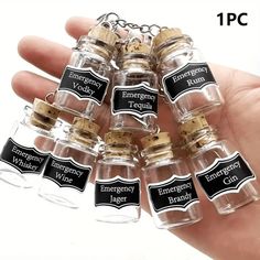 small glass bottles with labels on them are being held by someone's hand