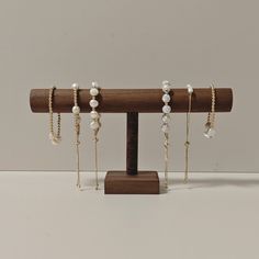 a wooden stand with five pairs of earrings on it