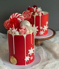 two red and white decorated cakes sitting on top of a table