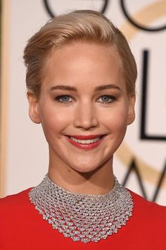 a close up of a person wearing a red dress and diamond choker on her neck