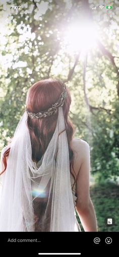 a woman wearing a veil and holding a flower in her hair with the sun shining behind her