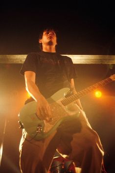 a man playing an electric guitar on stage