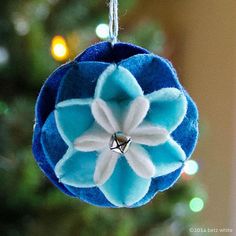 a blue and white ornament hanging from a christmas tree