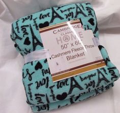 a blue blanket with black and white designs on it that has a tag attached to it