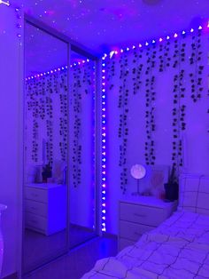 a bedroom decorated in purple and white lights