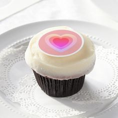 a cupcake on a plate with a sticker in the shape of a heart