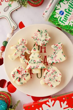 christmas cookies on a white plate with candy in the background