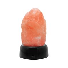 an orange rock sitting on top of a black stand