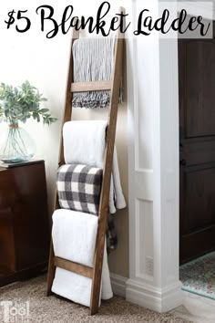 a wooden ladder leaning against the wall with towels on it and a potted plant next to it