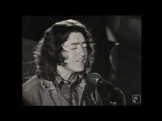 a black and white photo of a man singing into a microphone