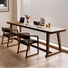 a wooden table with two chairs next to it on a hard wood floor in front of a window