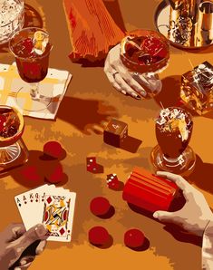 two hands holding playing cards over a table full of dices and cups with drinks