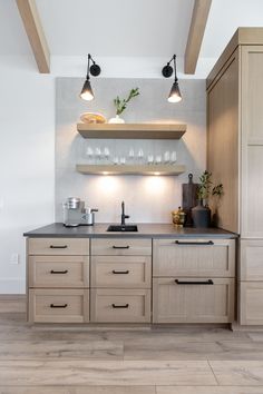 a kitchen with wooden cabinets and lights above the sink