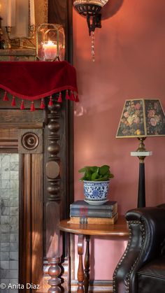 a room with a table, chair and lamp on it in front of a mirror