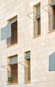 an apartment building with three balconies on the side and two windows above them