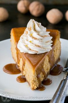 a slice of pumpkin cheesecake with whipped cream and caramel drizzle on top