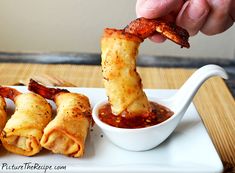 a person dipping some food into a small bowl