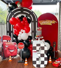 cars themed birthday party with balloons and race car decorations on the front porch for kids to enjoy