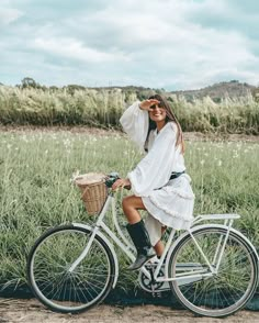 a woman in white dress riding a bike