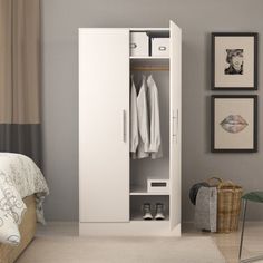 a white wardrobe with clothes hanging on it