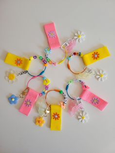 a bunch of bracelets that are on a white surface with flowers and beads around them