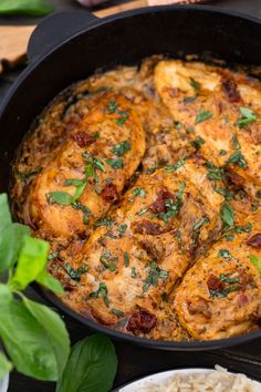 a pan filled with chicken and rice on top of a table next to some vegetables