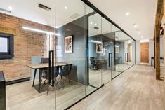 an office with glass walls and wooden floors