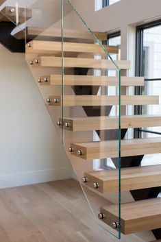 a glass staircase with wooden treads in a house