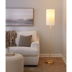 a living room scene with focus on the floor lamp and white couch in the background