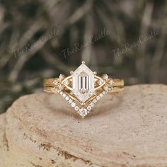 a white diamond ring sitting on top of a rock