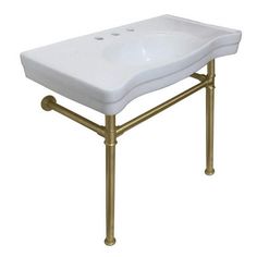 a white sink sitting on top of a gold metal stand with two faucets