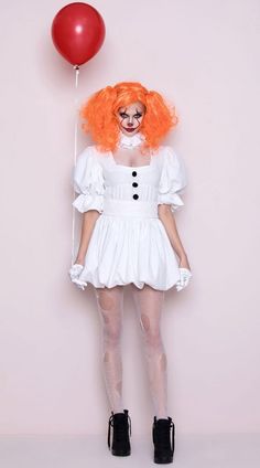 a woman with orange hair wearing a white dress and holding a red balloon