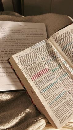 an open book sitting on top of a bed