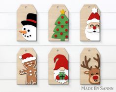 christmas gift tags with santa, snowman, reindeer and tree designs on them hanging from the wall